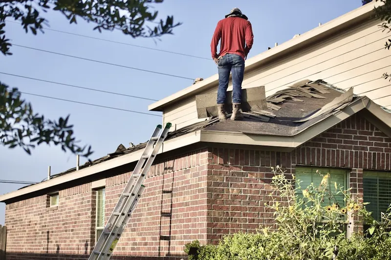 Professional roofer working on a residential roof in Tompkins Corners